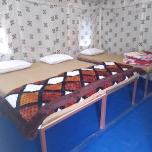 奈尼塔尔Valley view camps &cottages的一张床上的床上,上面有毯子