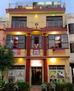 阿格拉Friends Guest House & Hostel- near TAJ MAHAL的一座建筑,上面有标志,现在已经写了