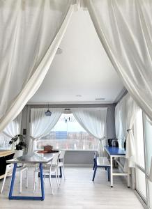 济州市Aewol Torini的客房设有桌椅和窗户。