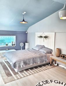 济州市Aewol Torini的一间卧室设有一张大床和蓝色的墙壁