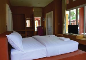 邦沙潘World Cat Beach & Resort เวิลด์แคท บีช แอนด์ รีสอร์ท的卧室内的一张大白色床,配有电视