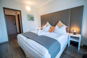 帕托内尔马克奥雷尔酒店的卧室配有带枕头的大型白色床
