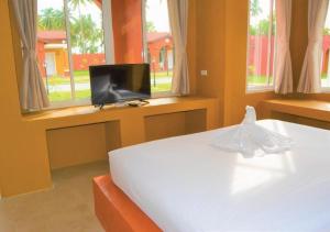 邦沙潘World Cat Beach & Resort เวิลด์แคท บีช แอนด์ รีสอร์ท的一间卧室设有一张床、电视和窗户