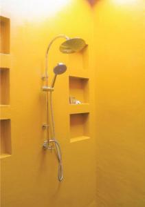 邦沙潘World Cat Beach & Resort เวิลด์แคท บีช แอนด์ รีสอร์ท的浴室设有黄色墙壁,配有淋浴。
