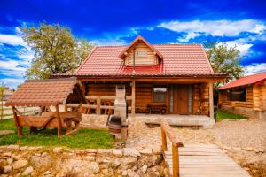 苏恰瓦Cabana La Matei的小木屋设有红色屋顶和围栏