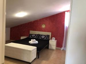 San SilvestroAtena B&B APARTMENTS Imperial的一间卧室设有一张黑色的床和红色的墙壁