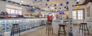 巴尔德佩尼亚斯Hostal Valdepeñas by Bossh Hotels的餐厅拥有蓝色和白色的瓷砖和凳子