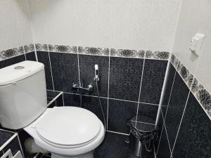 布哈拉Новая 3-х комнатная квартира Мечта的浴室设有白色卫生间和黑色瓷砖。