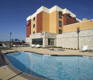 本殖民地Fairfield Inn & Suites by Marriott Dallas Plano The Colony的大楼前设有游泳池的酒店