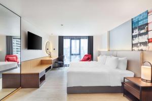曼谷Best Western Click Sathorn 11 Bangkok的酒店客房设有一张床、一张书桌和一台电视机。