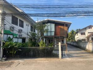 清莱Baan Jai Klang (บ้านใจกลาง)的前面有围栏的房子