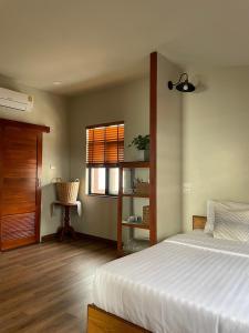 清莱Baan Jai Klang (บ้านใจกลาง)的一间卧室设有一张床和一个窗口