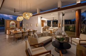 沙努尔Sumitra Luxury Villas A Pramana Experience的一间带桌椅的客厅和一间餐厅