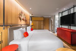 番路乡阿里山英迪格酒店的卧室配有一张白色大床和一台平面电视。