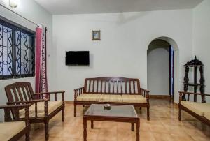 卡兰古特Super OYO Pravin Holiday Homes的客厅配有椅子、沙发和桌子