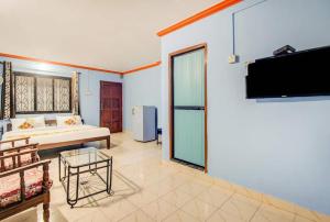 卡兰古特Super OYO Pravin Holiday Homes的一间卧室配有一张床和一台平面电视