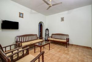 卡兰古特Super OYO Pravin Holiday Homes的客厅配有2张沙发和1台平面电视