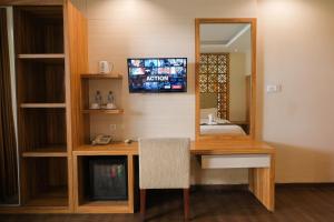 塞米亚克Kamarkoe Hotel Seminyak的客房设有带镜子的书桌和电视。