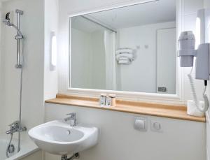 戛纳The Hollywood Hotel Cannes的白色的浴室设有水槽和镜子