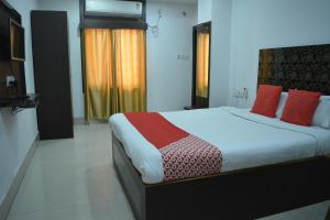 古瓦哈提HOTEL SHIVA的一间卧室配有一张带红色枕头的大床