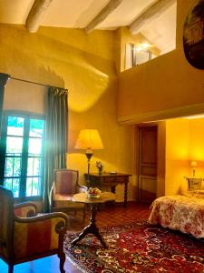 索尔格河畔利勒Maison d'hôtes Campagne-Baudeloup的卧室配有1张床、1张桌子和1把椅子