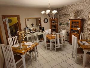 布隆方丹La Bohéme Gastehuis的厨房以及带木桌和椅子的用餐室。