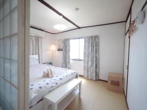 大阪Nippori Osaka Nishi-Tengachaya Guesthouse西天下茶屋アパートメント的白色的卧室设有床和窗户