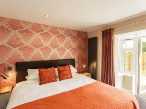 索海姆The Orange Tree Thornham的一间卧室配有一张带橙色毯子的床