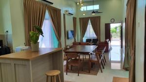 马六甲Duyong Damai Homestay by KOWBMAS的用餐室以及带桌椅的起居室。
