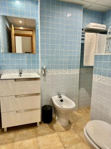 内尔哈Apartamento E&D的蓝色瓷砖浴室设有卫生间和水槽