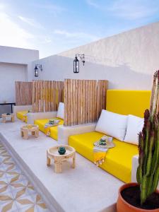 马拉喀什Riad Citrus的客厅设有黄色沙发和仙人掌