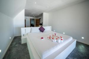 吉汶瓦Beachfront Villa Hideaway ZanzibarHouses的白色卧室,配有一张白色的红色玫瑰床