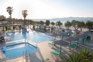 蒂加基阿克缇蒂密斯酒店的一个带遮阳伞和椅子的游泳池以及海滩