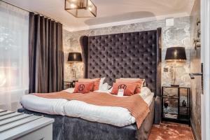 桑德维肯Högbo Brukshotell & Spa的一间卧室配有一张带橙色枕头的大床