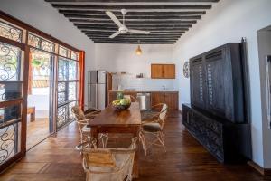 吉汶瓦Beachfront Villa Hideaway ZanzibarHouses的一间带木桌的厨房和一间餐厅