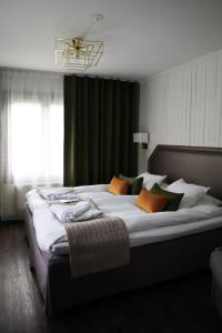 桑德维肯Högbo Brukshotell & Spa的一间卧室配有一张带枕头的大床