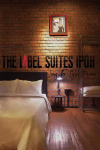 怡保The Label Suites Ipoh的一间卧室设有一张床和砖墙