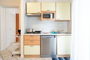 里米尼千禧公寓酒店的厨房配有白色橱柜和不锈钢冰箱