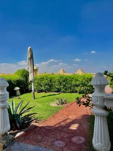 开罗Horus Mini Resort的一座带雕像和砖路的花园