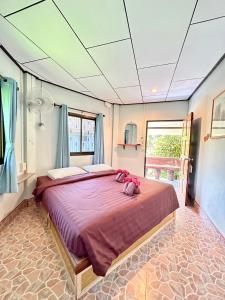 考索考索丛林小屋度假村的一间卧室配有一张大床,床上有粉红色的填充动物