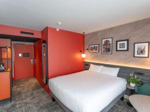 昂热昂热曼恩湖美居酒店的卧室设有白色的床和红色的墙壁