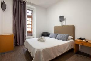波尔图波尔图科勒里古斯旅馆的一间卧室,床上放着两只动物