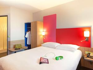 阿利仙罗马斯-瓦伦斯TGV车站宜必思尚品酒店的卧室配有一张白色大床和红色墙壁