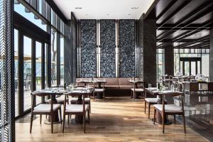 宁波宁波东钱湖华茂希尔顿酒店的餐厅设有桌椅和窗户。