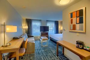 南本德Homewood Suites by Hilton South Bend Notre Dame Area的配有一张床和一张书桌的酒店客房