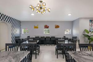 奥兰多Quality Inn & Suites Altamonte Springs Orlando-North的一间带桌椅和吊灯的用餐室