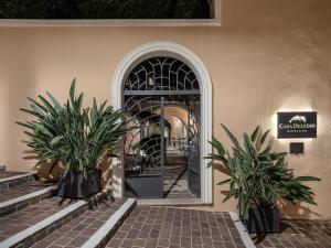 干尼亚卡萨德尔斐诺温泉酒店的门前有两株植物的建筑物入口