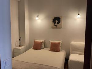波尔图Miguel Bombarda Cozy Apartment的客房设有两张床、一张沙发和灯具。
