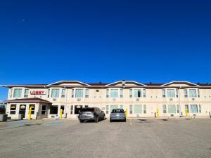 怀特考特Western Budget Motel #3 Whitecourt的两辆车停在停车场的酒店
