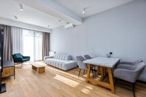 第比利斯Gratus Aparthotel Tbilisi的客厅配有沙发和桌椅